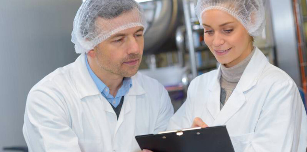 Deux collaborateurs en cuisine qui regardent un rapport qualité