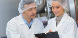 Deux collaborateurs en cuisine qui regardent un rapport qualité